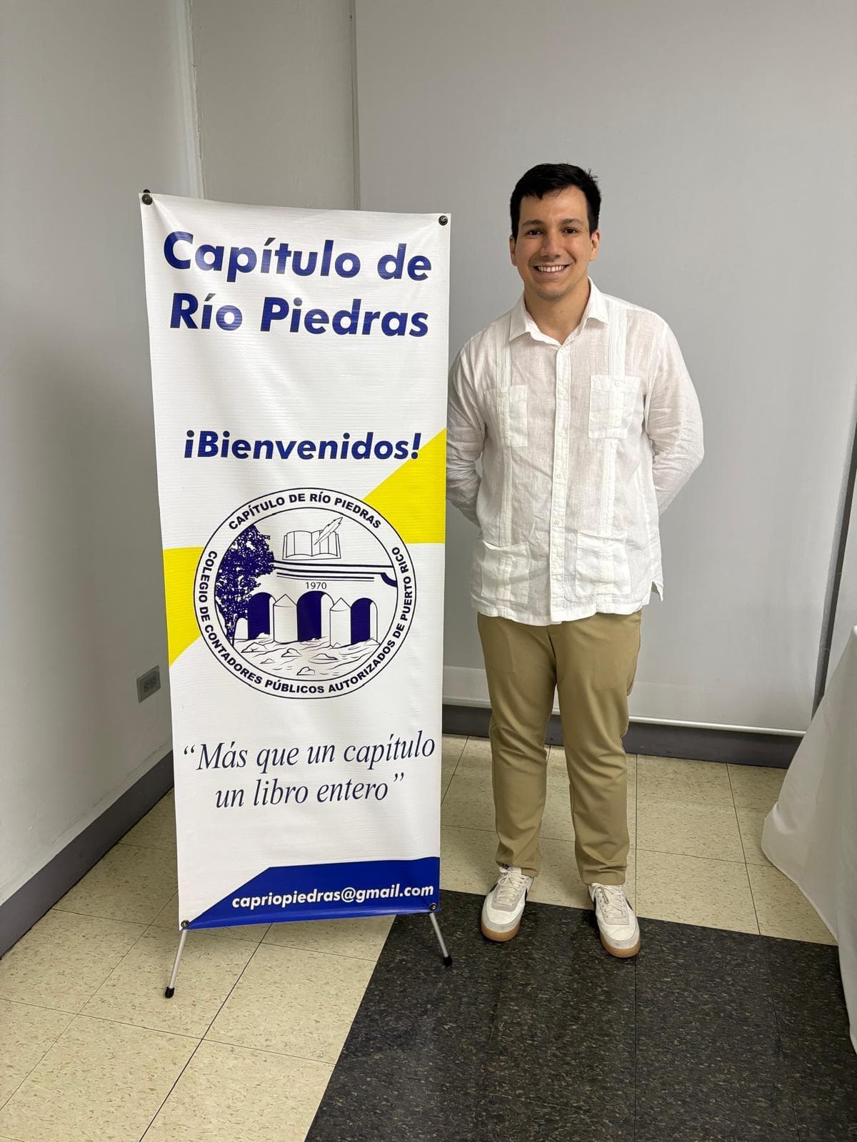 Rodolfo Romañach junto al banner del Capítulo de Río Piedras del Colegio de CPA