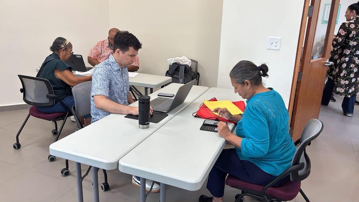 Rodolfo Romañach en una actividad de servicio a la comunidad, trabajando en su laptop junto a otras personas